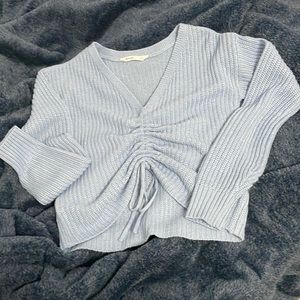 A knitted light blue sweater perfect for cold.